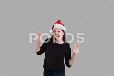Happy women wearing red Santa Claus holiday hat hand up Stock Photos