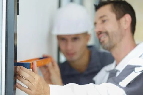 Happy worker inspecting using a builders level Stock Photos