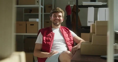 Happy worker of storage sitting and smiling, employee of warehouse, man wearing Stock Footage 157370062