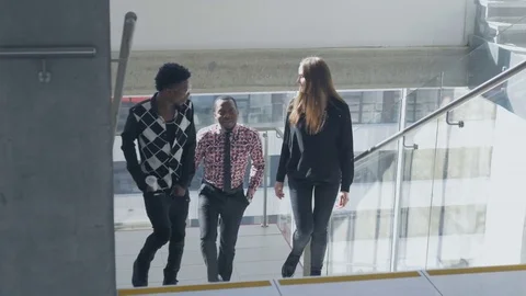 Happy workers enjoying a break while walking in a spacious office building Stock Footage 73852051