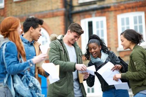Happy young adult college students reading exam results on campus Stock Photos