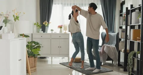 Happy young Asian couple enjoy cheerful time dancing together. Stock Footage 229714341