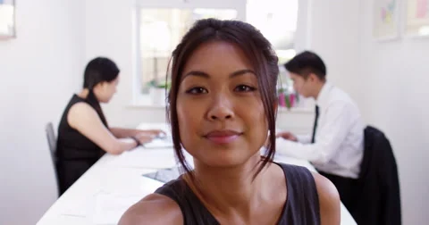 Happy young Asian manager having a video conference from her boardroom. Stock Footage 58693663