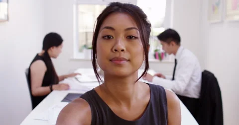 Happy young Asian manager having a video conference from her boardroom. Stock Footage 58695837