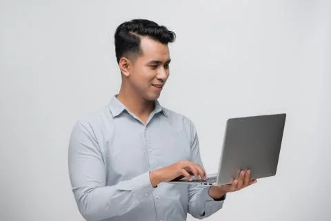 Happy young Asian software developer with laptop in his hands Stock Photos