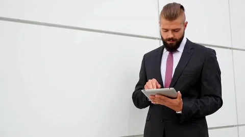 Happy young bearded businessman using his tablet pc. Outdoor photo. Stock Footage 60945259