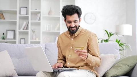 Happy young bearded man doing online shopping typing credit card number  Stock Footage 252200570