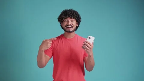 Happy young bearded multi-ethnic man 20s years old hold in hand use mobile cell Stock Footage 261738722
