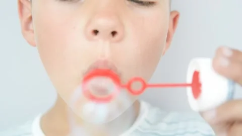 Happy young boy blowing soap bubbles Stock Footage 155106622