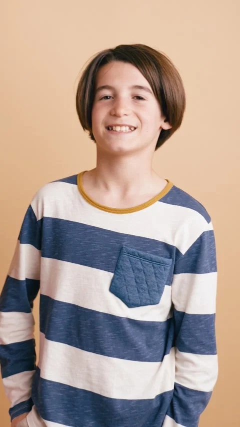 Happy young boy with a nice smile posing in studio. Vertical Stock Footage 341269665