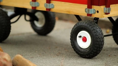 Happy young boy pulling his baby brother along in a wagon. Stock Footage 88405429