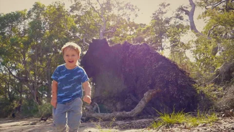 Happy young boy running toward camera on a bush track slow motion Stock Footage 130226090
