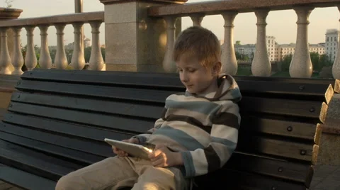 Happy young boy using tablet computer in the park Stock Footage 63121320