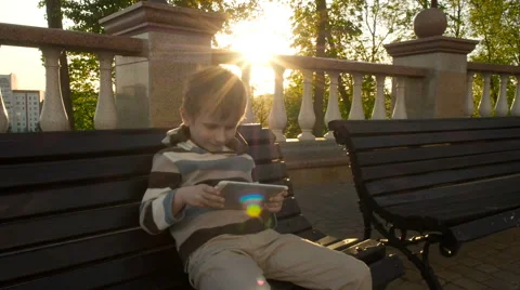 Happy young boy using tablet computer in the park Stock Footage 63121934