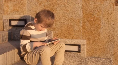 Happy young boy using tablet computer in the park Stock Footage 63122451