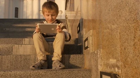 Happy young boy using tablet computer in the park Stock Footage 63123028