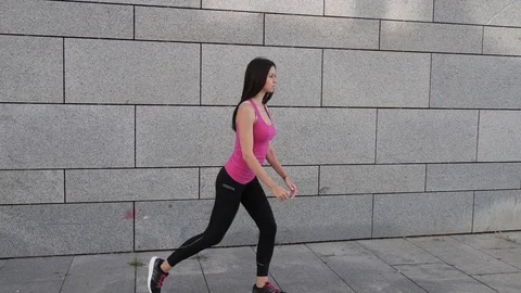Happy young brunette fitness woman athlete making workout outdoors in the city Stock Footage
