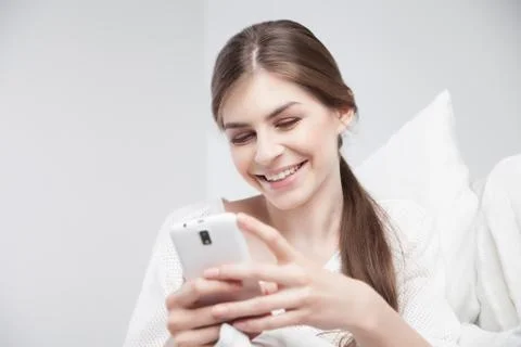 Happy young brunette using cell phone Stock Photos