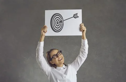 Happy young businesswoman holding picture of arrow in bullseye of shooting Stock Photos