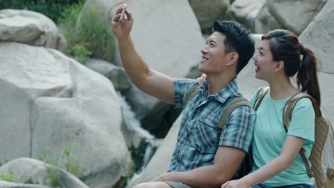 Happy young Chinese couple using smart phone outdoors,4K Stock Footage 155729909