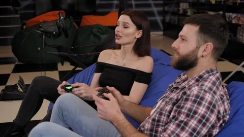 A happy young couple are playing video games in an entertaining game room. Stock Footage 267083580