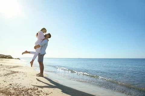 Happy young couple on beach near sea. Honeymoon trip Stock Photos