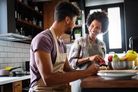 Happy young couple cooking together in the kitchen at home. Stock Photos