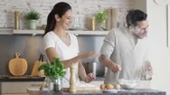 Happy Young Couple Cooks In The Kitchet. As A Joke They Started Throwing Flour. Stock Footage