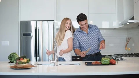 Happy young couple dancing in kitchen wearing pajamas listening to music morning Stock Footage 101854536