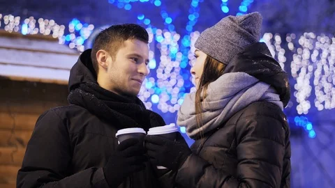 Happy young couple drinking coffee on the Xmas fair. Beautiful family chilling Stock Footage 100464787