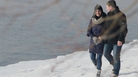 Happy young couple has fun walking next to bank of river outdoors Stock Footage 74076455