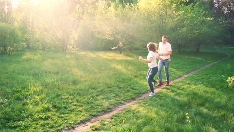 Happy young couple having fun in spring park. The guy runs after the girl Stock Footage 89520950