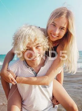 Happy young couple having fun at beach on sunny day Stock Photos
