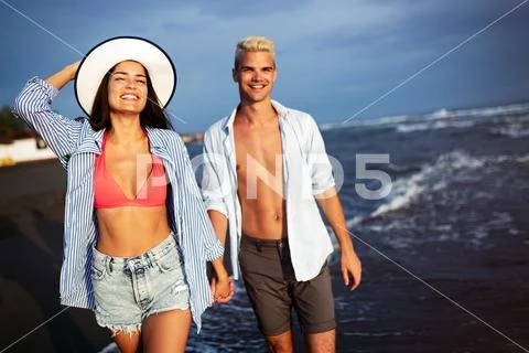 Happy young couple having fun and love at beach on sunny day Stock Photos