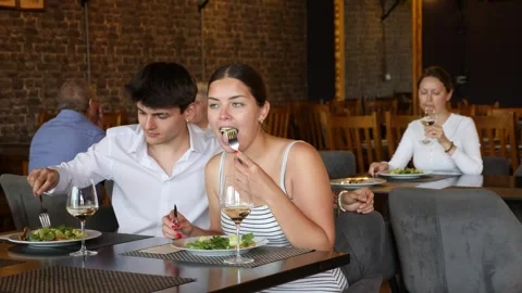 Happy young couple having romantic dinner in restaurant. Laughing girl and guy Stock Footage 341785580