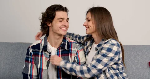 Happy young couple looking at each other with smile and embracing in living room 스톡 동영상 125614698