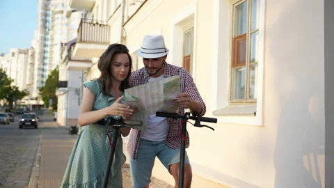 Happy young couple looking at the map while coming as tourists to the new city Video stock 232369658