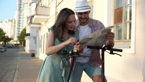Happy young couple looking at the map while coming as tourists to the new city Video stock 232369963