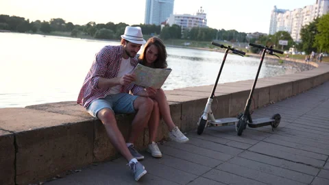 Happy young couple looking at the map while coming as tourists to the new city Video stock 232370175