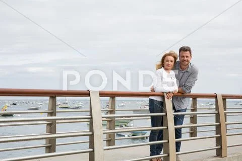 Happy young couple in love embracing on the bridge Stock Photos