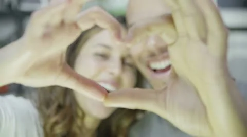 Happy young couple make a heart shape with their hands Stock Footage