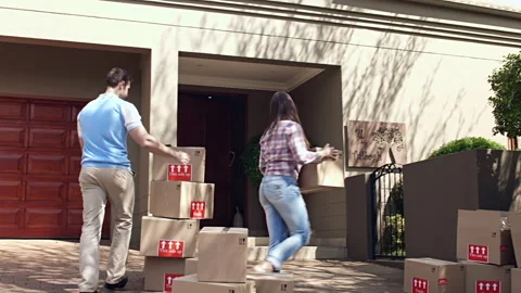 Happy young couple moving/ sorting their boxes while moving into a new house. 動画素材 199631932