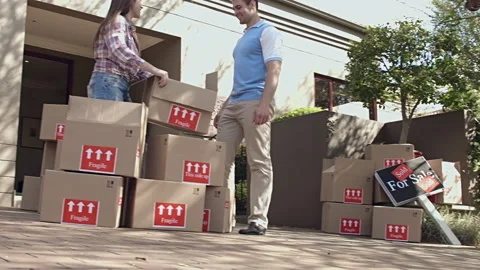 Happy young couple moving/ sorting their boxes while moving into a new house Vídeo Stock 199631964