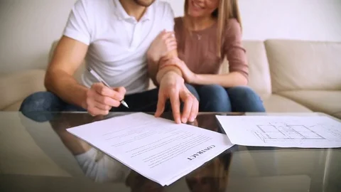 Happy young couple signing contract agreement and hugging, mortgage investment Stock Footage