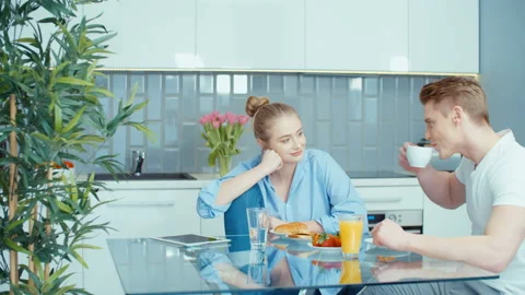 Happy young couple sitting at dining table and talking. Stock Footage 86719088