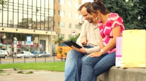 Happy young couple with tablet computer in the city, steadycam shot Vídeo Stock 8683269