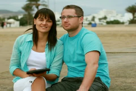 Happy young couple with tablet computer on the beach Stockbeeldmateriaal 10791424