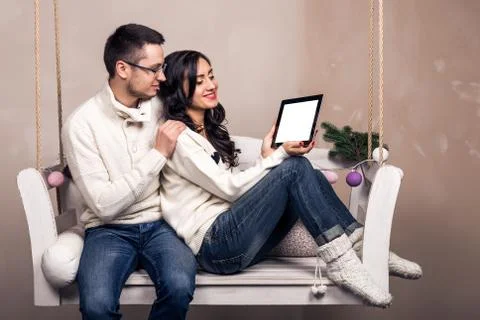Happy young couple with a tablet computer on swing Stock Photos