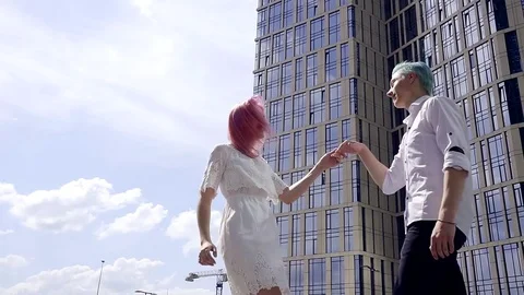 Happy young couple of teenagers are dancing in the business district of the city Stock Footage
