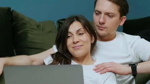 Happy young couple using laptop for ecommerce, doing online shopping together. Stock Footage 150896801